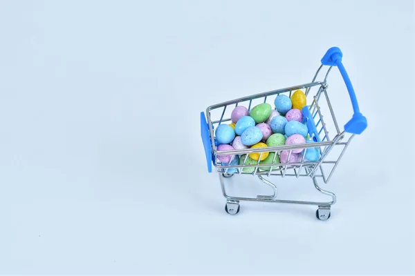 Einkaufswagen Mit Bunten Ostereiern Auf Weißem Hintergrund Osterverkauf Selektiver Fokus — Stockfoto
