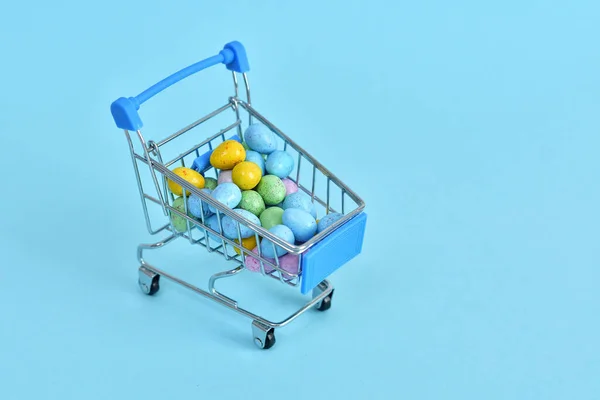 Einkaufswagen Mit Bunten Ostereiern Auf Blauem Hintergrund Osterverkauf Selektiver Fokus — Stockfoto