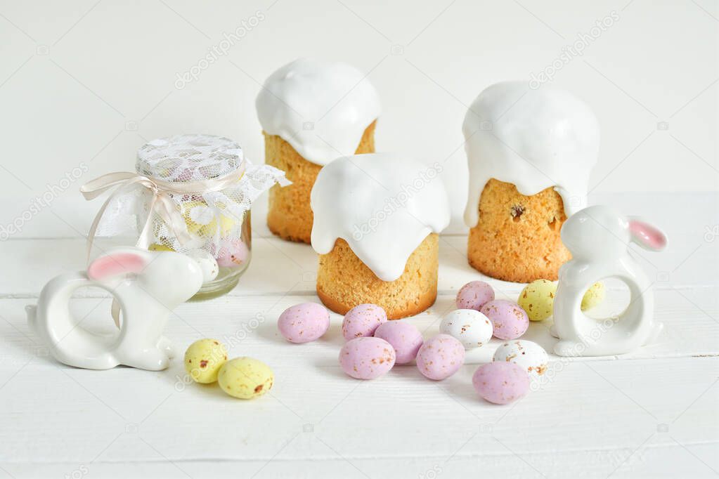 Easter sweets and decorations background. Traditional sweet cake with colorful painted eggs, easter Bunny and decor. Copy space. Selective Focus