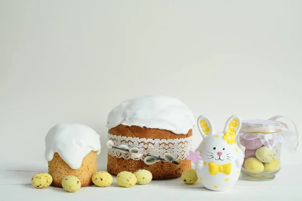 Easter sweets and decorations background. Traditional sweet cake with colorful painted eggs, chocolate hens and decor. Copy space. Selective Focus