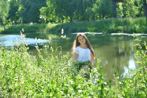 在河边的夏天的草地上 一个戴着美丽花环的女孩 库帕尔的节日 地球日 7月7日 乌克兰传统的带有算命和占卜仪式的奴隶假期 — 图库照片