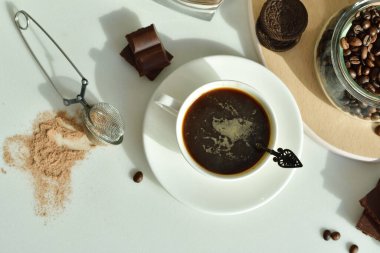 Bir fincan sade kahve ve kahve çekirdeği, bir parça çikolata. Günaydın konsept. Uzayı kopyala Seçici odaklanma. Üst görünüm