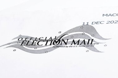 Vidalia, Georgia / USA - December 16, 2020: An illustrative macro shot of the official United States election mail logo print on the front of a white mailing envelope. clipart