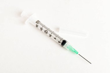 Tek kullanımlık tek kullanımlık plastik enjeksiyon setinin seçici odak noktasını beyaz arka planda gösteren yakın çekim..