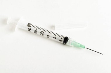 Tek kullanımlık tek kullanımlık plastik enjeksiyon setinin seçici odak noktasını beyaz arka planda gösteren yakın çekim..