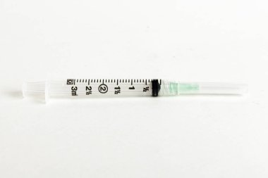 Tek kullanımlık tek kullanımlık plastik enjeksiyon setinin seçici odak noktasını beyaz arka planda gösteren yakın çekim..