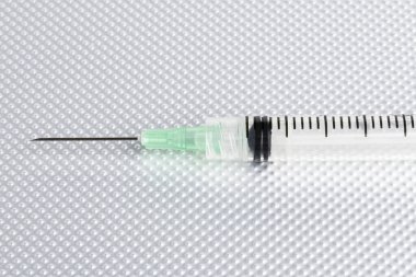 Metal bir arka planda tek kullanımlık tek kullanımlık plastik enjeksiyon setinin seçici odak noktasıyla yakın çekim..