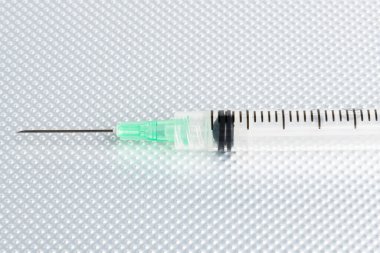 Metal bir arka planda tek kullanımlık tek kullanımlık plastik enjeksiyon setinin seçici odak noktasıyla yakın çekim..