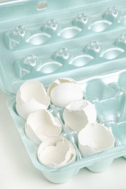 Çatlamış beyaz yumurta kabuklarının yakın plan çekimi. Tek tek strafor tepsinin çekirdeklerine yerleştirilmiş..