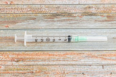 Tahta desenli arka planda tek kullanımlık tek kullanımlık plastik enjeksiyon enjeksiyonunun seçici odak noktası olan yakın çekim..