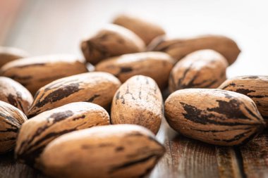 Seçici odaklı bir makro fotoğraf. Tahta bir masaya yerleştirilmiş kabuklu ceviz..