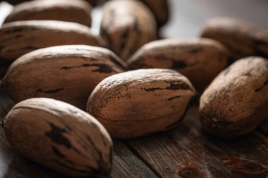 Seçici odaklı bir makro fotoğraf. Tahta bir masaya yerleştirilmiş kabuklu ceviz..