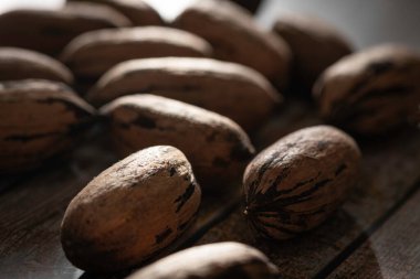 Seçici odaklı bir makro fotoğraf. Tahta bir masaya yerleştirilmiş kabuklu ceviz..