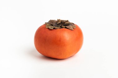 Close-up shot with shallow depth of field of a ripe persimmon fruit set on a plain white background. clipart