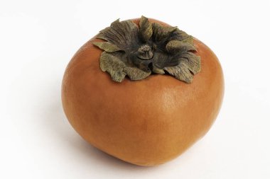 Close-up shot with shallow depth of field of a ripe persimmon fruit set on a plain white background. clipart