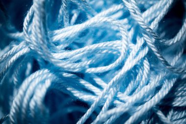 An extreme close-up with selective focus of blue and fuzzy bundled crochet threads. clipart