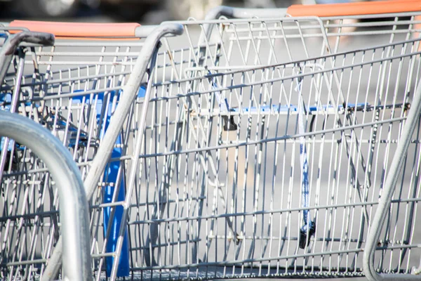 A close-up shot of a shopping cart at the parking lot of a grocery store.