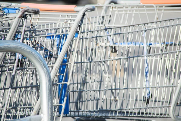 A close-up shot of a shopping cart at the parking lot of a grocery store.