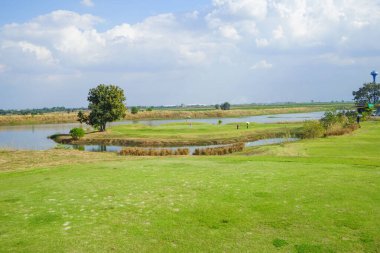 Oyuncularla dolu golf sahası manzarası. Golf sahasındaki golfçülerin havadan görünüşü. Güneşli bir günde güzel bir golf sahası. Arka plandaki golf sahasında güneş ışığı parlıyor. Kırsaldaki golf sahasında.                              
