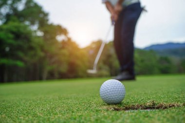 Bulanık golfçü akşam vakti golf sahasında golf oynuyor. Güneşin altında golf oynayan bir adam..                               