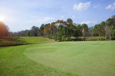 Akşam golf sahasının arka planında Tayland 'daki golf sahasında güneş ışığı var. Bir yaz öğleden sonra golf sahasında güzel bir manzara..                                