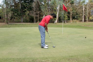 Bulanık golfçü akşam vakti golf sahasında golf oynuyor. Güneşin altında golf oynayan bir adam..