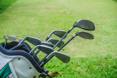 Yeşile yakın eski golf çantaları. Yeşil alan arka planında golf sopaları..                               