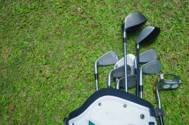 Yeşile yakın eski golf çantaları. Yeşil alan arka planında golf sopaları..                               