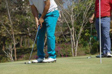  Golfçüler golfü akşam golf sahasına koyuyorlar. Golfçü golf topuna vuruyor. Spor tatil yaşam tarzı kavramı.                              