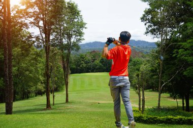 Akşam golf sahasında golf oynayan bir golfçü. Güneşin altında golf oynayan bir adam..                               