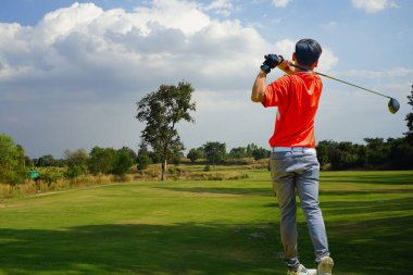 Akşam golf sahasında golf oynayan bir golfçü. Güneşin altında golf oynayan bir adam..                               