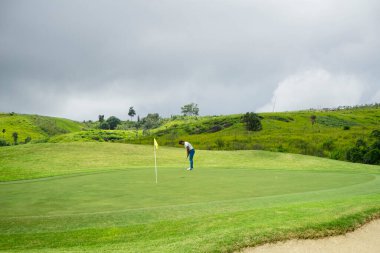 Golfçüler golfü akşam golf sahasına koyuyorlar. Golfçü golf topuna vuruyor. Spor tatil yaşam tarzı kavramı.                               