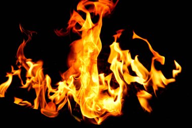 Siyah arka planda yangın alevleri. Doğal ormandaki yangın, alevler ve kıvılcımlar arka planda karanlık bir yakıt, siyah bir arka planda ışıklar.