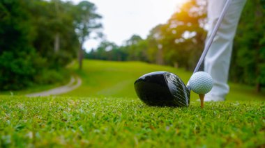 Akşam golf sahasında golf oynayan bir golfçü. Güneşin altında golf oynayan bir adam..                               