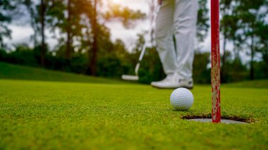 Golfçüler golfü akşam golf sahasına koyuyorlar. Golfçü golf topuna vuruyor. Spor tatil yaşam tarzı kavramı.                                 