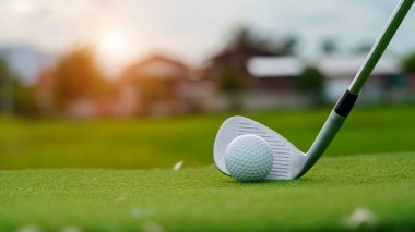 Golf sopaları ve golf topları yeşil çimlerde sabah güneşli güzel bir golf sahasında. Yeşil çimlerde golf ekipmanlarını kapatın..