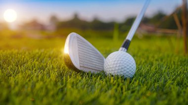 Golf sopaları ve toplar yeşil çimlerde sabah güneşli güzel bir golf sahasında. Yeşil çimlerde golf ekipmanlarını kapatın..