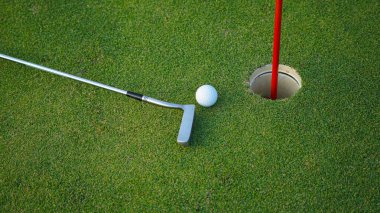 Golf sopaları ve golf topları yeşil çimlerde sabah güneşli güzel bir golf sahasında. Yeşil çimlerde golf ekipmanlarını kapatın..