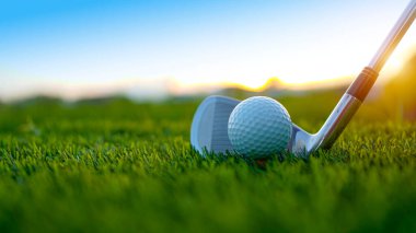 Golf sopaları ve toplar yeşil çimlerde sabah güneşli güzel bir golf sahasında. Yeşil çimlerde golf ekipmanlarını kapatın..