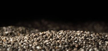 Siyah arkaplanı olan chia tohumlarını kapat