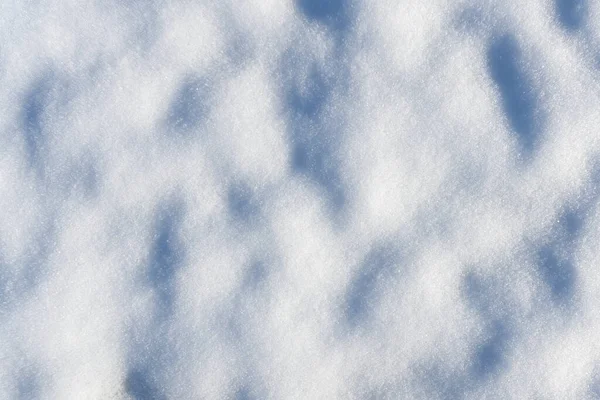 雪の上から直接見られる凹凸のある表面と影で覆われた地面を閉じます ストックフォト