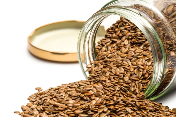 Linseed in an overturned glass jar — Stock Photo, Image