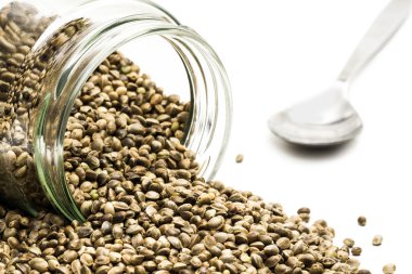 Kenevir tohumu devrilmiş bir cam kaşık ile