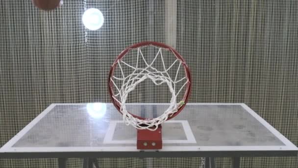 Uma bola de basquete atinge o aro câmera lenta a partir de baixo — Vídeo de Stock