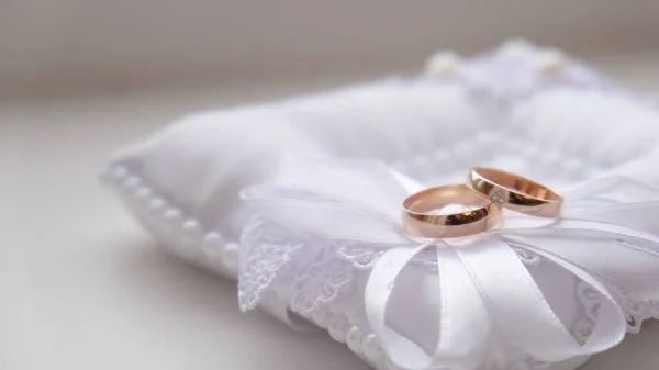 Belos anéis de casamento dourados deitados em cima uns dos outros, close-up. — Fotografia de Stock