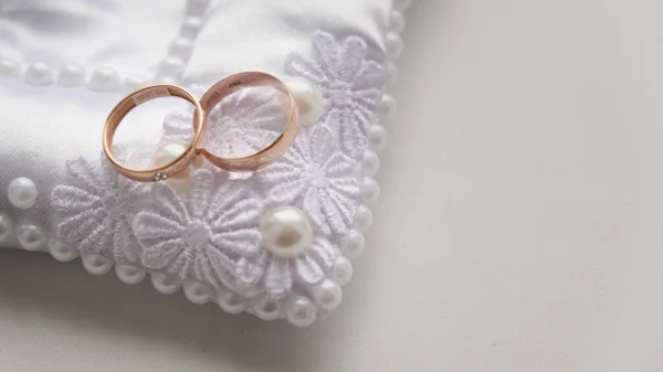 Belos anéis de casamento dourados deitados em cima uns dos outros, close-up. — Fotografia de Stock