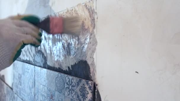 Чоловіча рука з пензлем наносить ґрунтовку на стіну — стокове відео