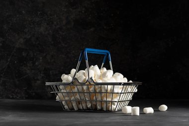 Market sepetinde beyaz, havadar şekerlemeler, sade bir arka planda.