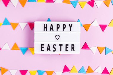 Beyaz tahtada mutlu paskalya harfleri pembe arka planda keçeli çelenk