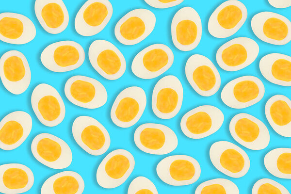 Pattern of many boiled cut eggs on a blue background